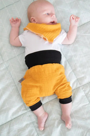 Weiches Musselin-Dreieckstuch in verschiedenen Mustern, ideal für Babys, mit natürlicher Textur und angenehmem Tragekomfort.