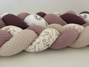 Ein Bild der einfachen Bettschlangen aus der Bildergalerie von Mein Shop, in neutralen Farben auf einem Bett liegend.