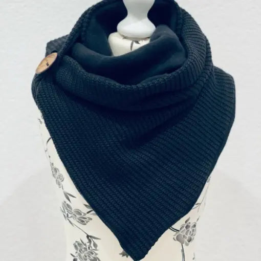 Schwarzer Wickelschal im Dreieckstuch-Design, gestrickt, einfaches Accessoire für kalte Tage, zeigt die Textur des gestrickten Stoffes