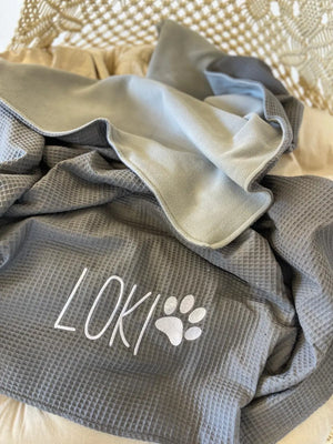 Personalisierte Hundedecke in Wunschfarben, weiche Sofadecke für Hunde mit individuellem Design, auf einem Sofa liegend