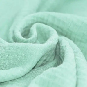 Klares Mint-XXL-Bio-Musselintuch mit Knopf, vielseitiger Schal aus Baumwolle, zeigt die Textur und den Knopfverschluss.