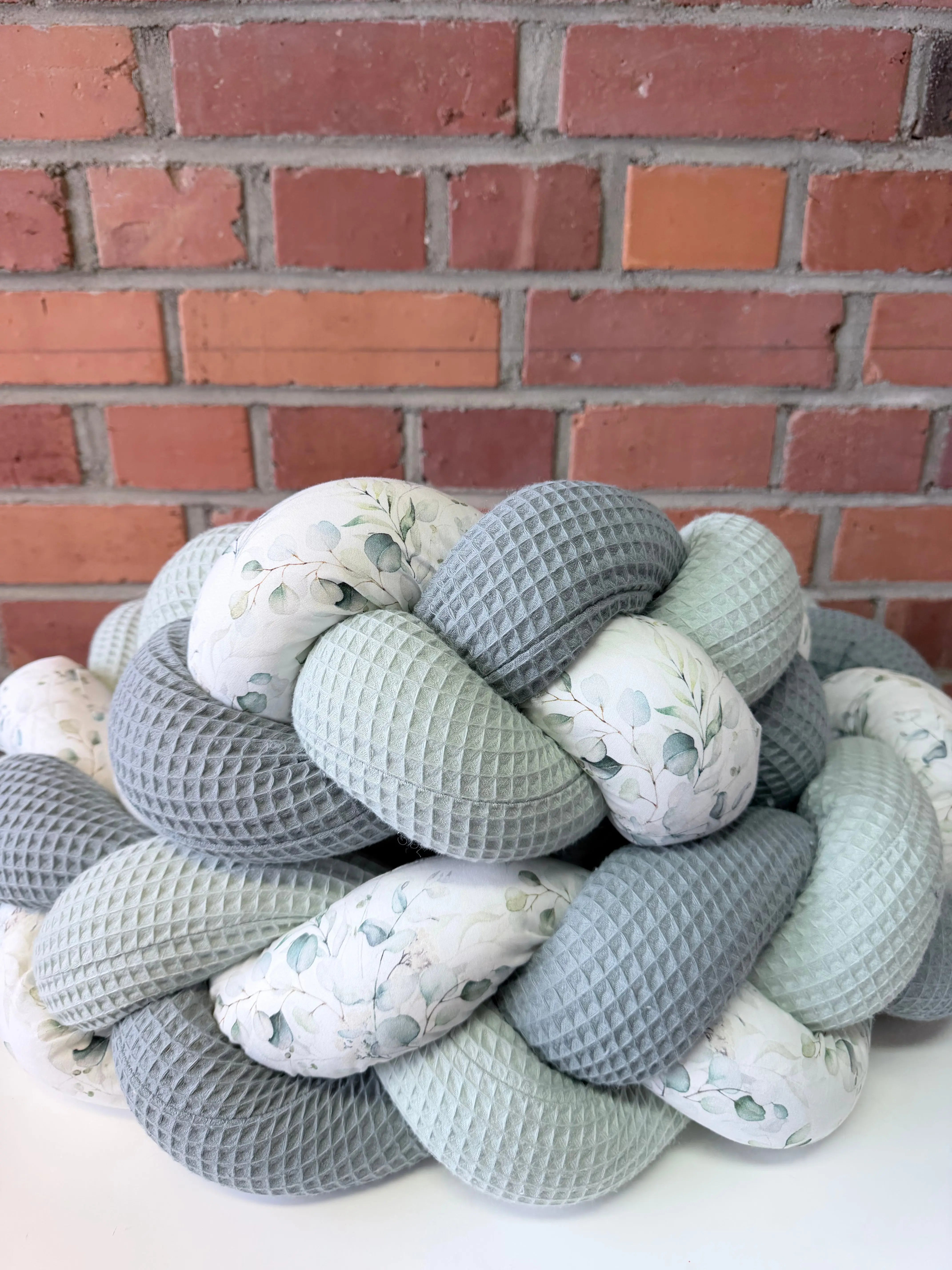 Bettschlange von Janines Fadenzauber, weiche Stoffe und bunte Muster, ideal für Babys und Kinderbetten.