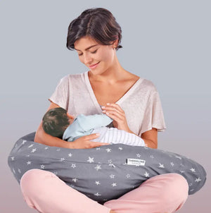 Theraline Stillkissen mit individuellem Bezug, Modell auf einem Bett, bequem zum Stillen und Entspannen, in natürlicher Umgebung.