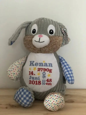 Bunter Harlequin Hase in Blau, variabler Stoff, detailreiche Nähte und fröhliches Design, auf weißem Hintergrund.